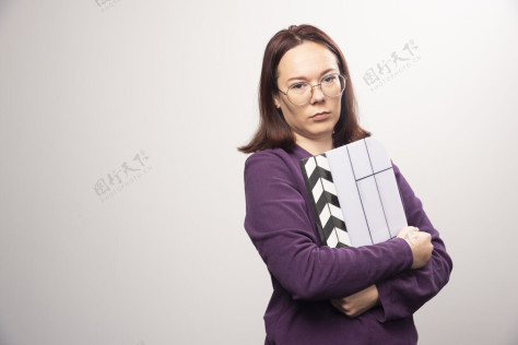 女士一个年轻的女人在一张白色的照片上摆着一个电影院的带子高质量的照片年轻人女性镜头