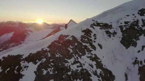 日出时登山者到达山顶的鸟瞰图