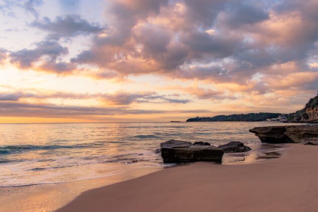 海岸美丽的夕阳下岩石海滩的迷人景色海滩海湾惊人