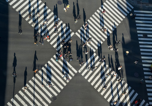 Aerial view of people passing crosswalk in the downtown street.