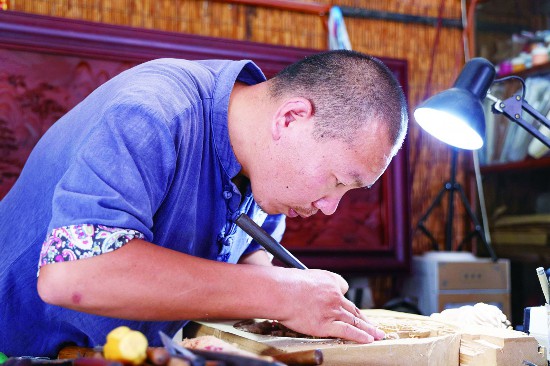 Fu Yijie sedang membuat kerja ukiran kayu. (Foto/www.bozhou.cn)