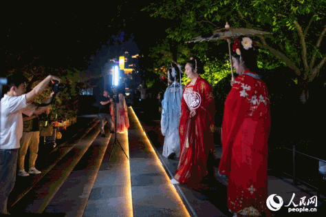 Pelancong yang berpakaian Hanfu, pakaian tradisional etnik Han, dan pakaian Dinasti Tang (618-907), bergambar di bandar Datang Everbright, sebuah mercu tanda pelancongan di Xi'an, ibu kota provinsi Shaanxi, di barat laut China. (People’s Daily Online/Weng Qiyu)