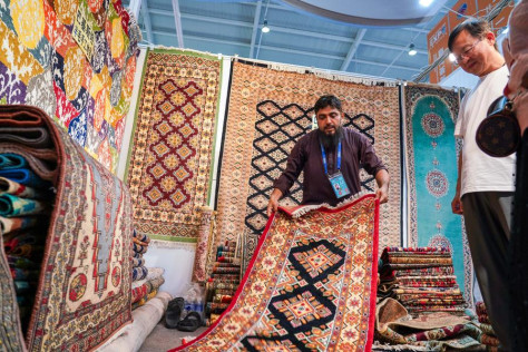 Un espositore pakistano presenta i tappeti ai visitatori del padiglione dell'Asia Meridionale durante l'ottava edizione della China-South Asia Expo a Kunming, nella provincia sud-occidentale cinese dello Yunnan. (26 luglio 2024 - Xinhua/Wang Jingyi)