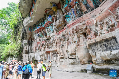 Τουρίστες επισκέπτονται το γραφικό σημείο των βραχογραφιών Ντατζού στον δήμο Τσονγκτσίνγκ, στις 7 Ιουλίου. (Φωτογραφία / Xinhua)