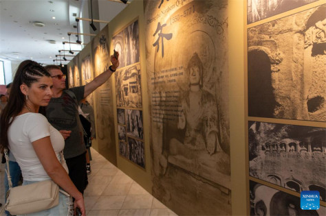 Επισκέπτες παρακολουθούν την παρουσίαση της τέχνης των κινεζικών σπηλαίων στο Ζάππειο Μέγαρο στην Αθήνα, στις 11 Μαΐου. (Φωτογραφία / Xinhua)