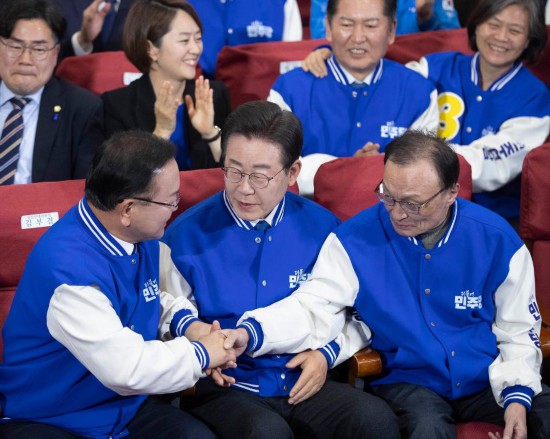 4月10日，在韩国首尔，韩国共同民主党党首李在明（前排中）与共同民主党领导层共同庆祝出口民调结果大幅领先。新华社记者姚琪琳摄