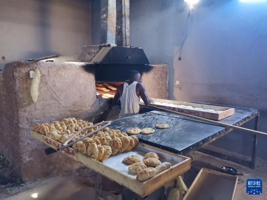 7月1日，一名员工在苏丹首都喀土穆西部恩图曼市的一家大饼店内制作大饼（手机照片）。新华社发（穆罕默德·海德尔摄）