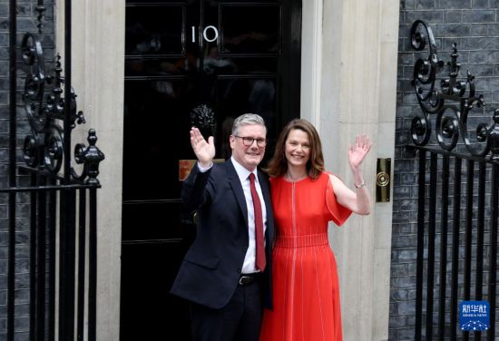 7月5日，基尔·斯塔默发表讲话后与妻子在英国伦敦唐宁街10号首相府前挥手致意。 新华社记者 李颖 摄