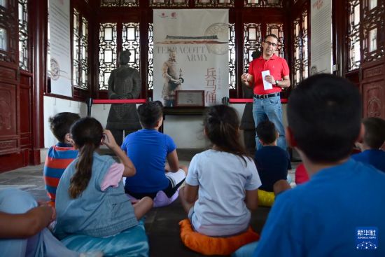 7月4日，在马耳他桑塔露琪亚市的中国古典园林“静园”，人们聆听关于兵马俑的讲解。新华社发（乔纳森·博格 摄）