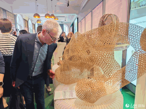 伦敦手工艺周主席盖伊·索尔特在认真欣赏竹编雕塑作品《石为云根》。人民网记者 邢雪摄