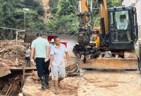 6月28日，平远县泗水镇圩镇，人们正在清理山体滑坡带下来的泥石等。人民网 张永生摄