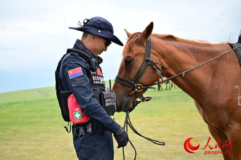 “海东青”骑警队队员达林台和他的队友“清风”。人民网记者 寇雅楠摄