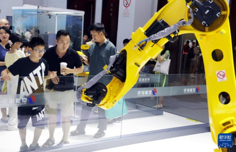 科博会会場で、ロボットアームを見学する来場者（7月14日撮影・潘旭）。