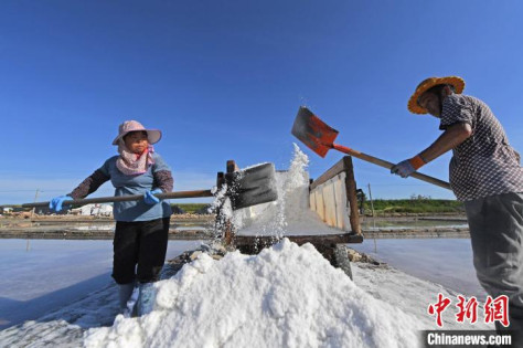 収穫した原塩をトラックに積み込む作業員（7月10日撮影・林弘梫）。