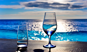 酒杯玻璃杯特写与波光水面摄影图片