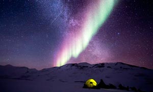 雪山顶上美丽的极光摄影图片