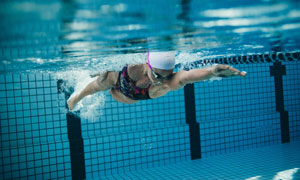 清澈泳池中的游泳人物摄影高清图片