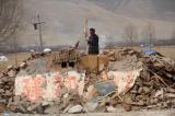 图文：男子在玉树地震废墟上寻找生活用品