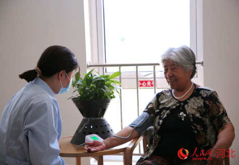 承德市寿康康养中心的医护人员为入住长者测量血压。人民网记者 周博摄