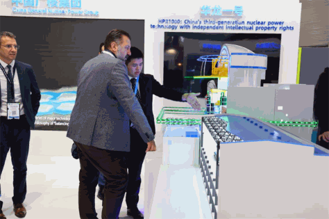 Des visiteurs s’arrêtent pour en apprendre davantage sur la maquette de centrale nucléaire « Hualong 1 » sur le stand de la China General Nuclear Corporation (CGN) lors de la 5e Exposition mondiale de l