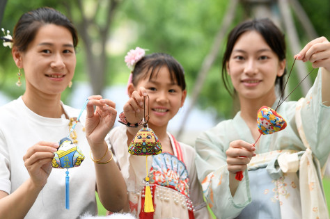 武汉颐湖公园举行“我们的节日·端午·‘粽’享非遗”活动，游园市民缝制香囊。（图片来源：视觉中国）
