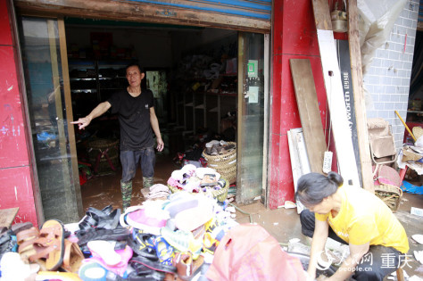 仁沙镇居民向记者介绍洪水最高的位置。人民网记者 刘政宁摄