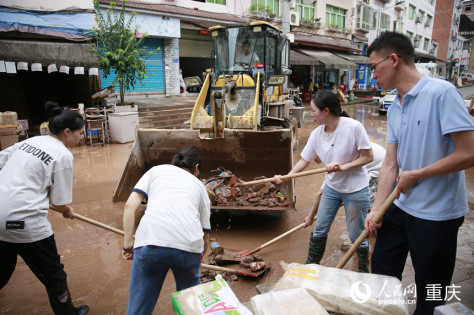 志愿者和群众合力清理仁沙镇场镇的淤泥和杂物。人民网记者 刘政宁摄