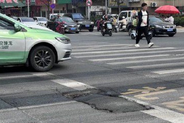 郑州这个交叉口路面坑洼严重 过往车辆一不小心就被“坑”