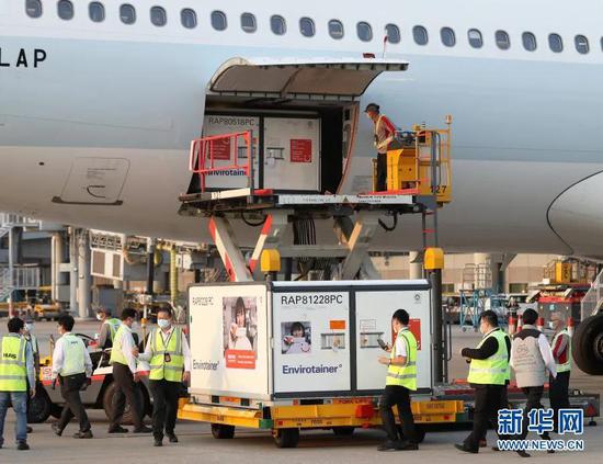 2月19日，在香港国际机场，工作人员将装载疫苗的货柜箱送往指定地点进行储存。新华社记者 李钢 摄